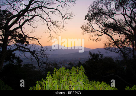 Vue d'un coucher du soleil dans un cadre d'arbres pour signifier un concept de tourisme Banque D'Images