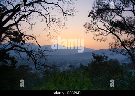 Vue d'un coucher du soleil dans un cadre d'arbres pour signifier un concept de tourisme Banque D'Images