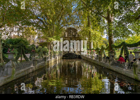 Personnes assises près de l'étang à la fontaine Medici ou Fontaine de Médicis, une fontaine monumentale, un jour d'été dans le jardin du Luxembourg, Paris Banque D'Images