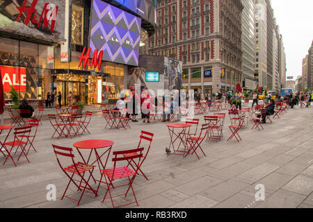 New York, NY, USA -- le 8 juin 2015. Tables et chaises rouges sont mis en place dans une zone piétonne à midtown plaza près de Times Square. Banque D'Images