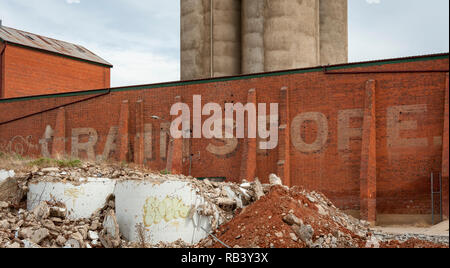 Un vieux et a disparu à Grain Store inscription peinte sur un mur de brique rouge avec les silos à grains debout dans l'arrière-plan Banque D'Images