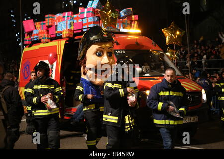 Madrid, Madrid, Espagne. 5e Jan, 2019. Pompiers qui décorent leurs véhicules avec de nombreux paquets cadeaux vu défiler à côté d'un géant avec le casque de pompier volontaire au cours de l'événement.Peuple réuni avec la famille et les enfants pour les trois rois de l'Orient Madrid 2019, ceux-ci viennent avec plus de huit chars et trois membres de la famille royale, deux mille personnes qui forment le grand cortège, accompagné de quatre entreprises internationales que distribuer des cadeaux et des illusions. Crédit : Mario Roldan SOPA/Images/ZUMA/Alamy Fil Live News Banque D'Images