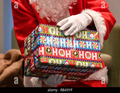 Berlin, Allemagne. Dec 21, 2018. Un pack cadeau dans les mains d'un Père Noël. Credit : Jens Kalaene Zentralbild-/dpa/ZB/dpa/Alamy Live News Banque D'Images