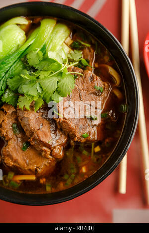 Soupe aux nouilles boeuf braisé taiwanais avec des baguettes sur la table d'un restaurant chinois Banque D'Images