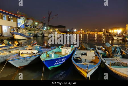 KAOHSIUNG, TAIWAN -- 22 DÉCEMBRE 2018 : un petit port de pêche de nuit sur l'île de Qijin. Dans l'arrière sont des réservoirs de stockage de carburant coloré. Banque D'Images