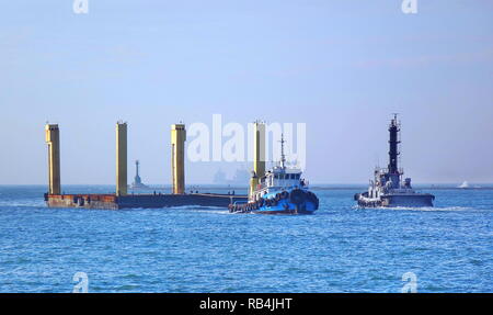 KAOHSIUNG, TAIWAN -- 22 DÉCEMBRE 2018 : un remorqueur tire un grand élément de construction en acier flottant dans le port de Kaohsiung. Banque D'Images