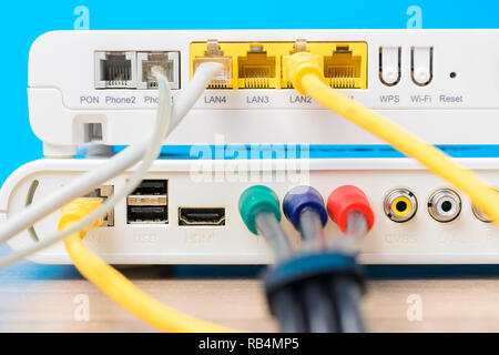 Accueil routeur sans fil avec des câbles Ethernet branché sur fond bleu, Close up Banque D'Images