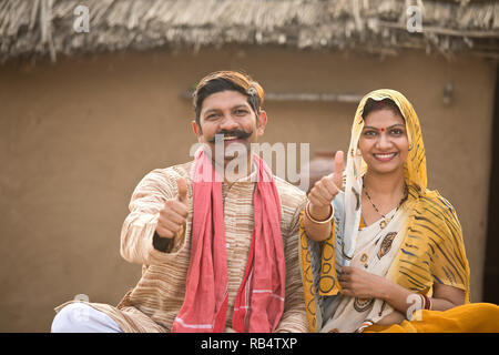 Portrait de couple de l'Inde rurale gesturing Thumbs up à village Banque D'Images