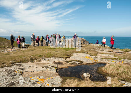 Un groupe de marcheurs dans la distance sur Shipman, tête Bryher, Îles Scilly, par un beau jour de printemps ensoleillé. Banque D'Images