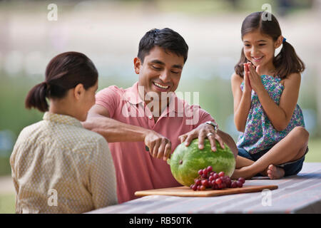 La pastèque en famille au cours d'un pique-nique au parc. Banque D'Images