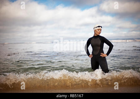 Jeunes femmes athlètes préparent à nager à la plage Banque D'Images
