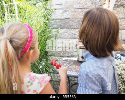 Garçon et fille de manger d'une fontaine de chocolat. Banque D'Images