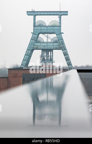 Der Förderturm der Zeche Ewald spiegelt sich in einem Geländer. Banque D'Images