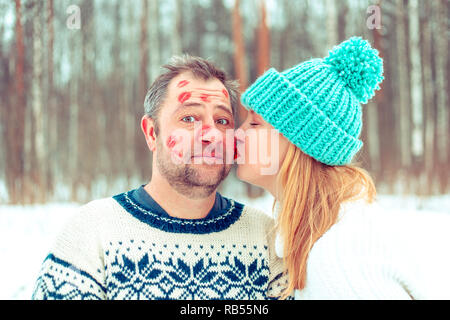 Couple heureux en amour en serrant l'hiver forêt couverte de neige. Sur le visage d'un homme il y a des traces de rouge à lèvres. Banque D'Images