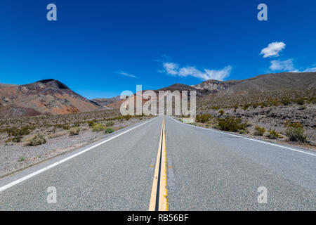 Paysage avec un long désert route droite dans la Death Valley National Park, California, USA. Banque D'Images