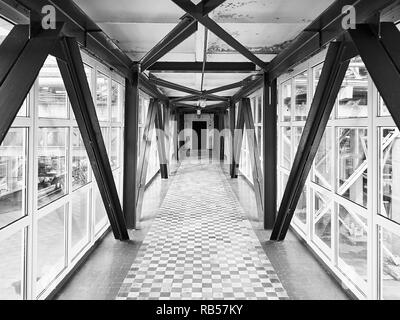 Un pont aérien ou de transition entre les bâtiments de l'usine de produits chimiques à haute altitude au-dessus du sol d'économiser du temps de passage pour les travailleurs et sol carrelé dans galerie fenêtré Banque D'Images