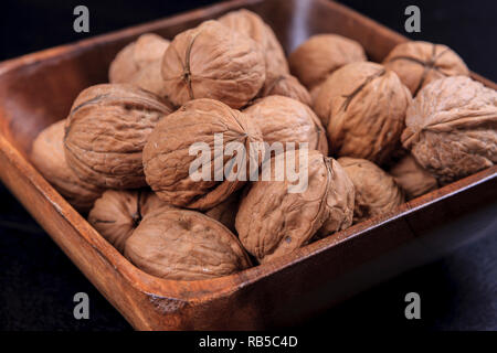 Un portrait photo de les noix dans un bol en bois. Banque D'Images