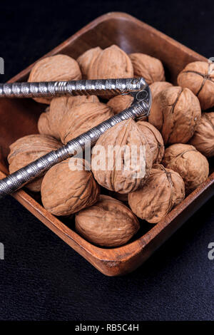 Un portrait photo de les noix et un casse-noix dans un bol en bois. Banque D'Images