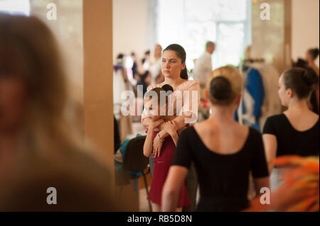Jeune belle mère embrassant sa petite danseuse ballerine Girl standing in dance school en répétition avant le spectacle Banque D'Images