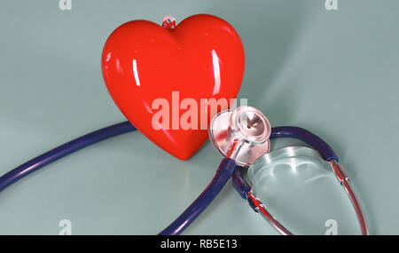 Coeur rouge avec stéthoscope sur fond en bois bleu. Banque D'Images