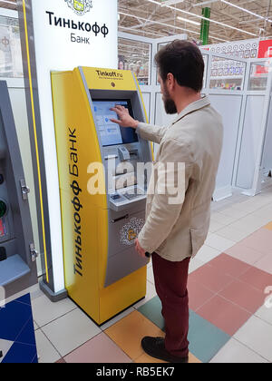 Samara, RUSSIE - le 26 août 2018 : bearded Caucasian middle-aged businessman apparition utilise une carte de crédit à un distributeur automatique de banque Tinkoff. Banque D'Images