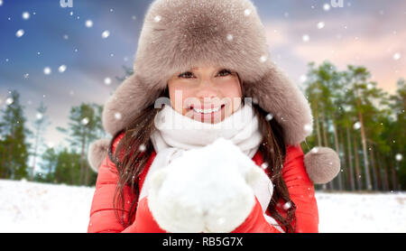 Femme au chapeau de fourrure avec de la neige en forêt d'hiver Banque D'Images