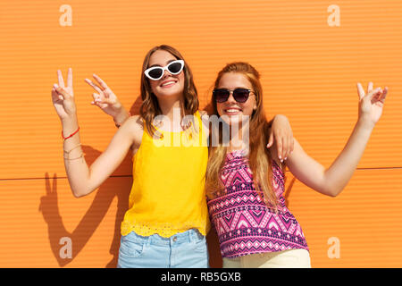 Smiling teenage girls montrant la paix en été Banque D'Images