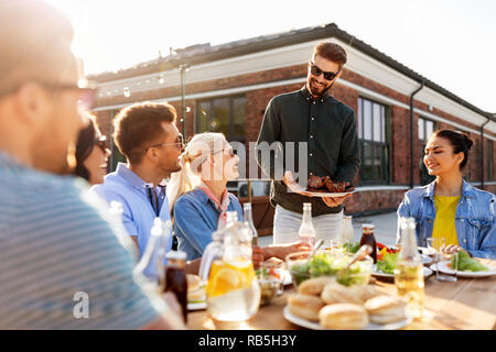 Amis à la partie de barbecue sur le toit en été Banque D'Images