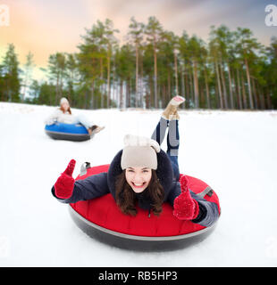 Teenage girl glissant sur la colline parlementaire le snow tube Banque D'Images