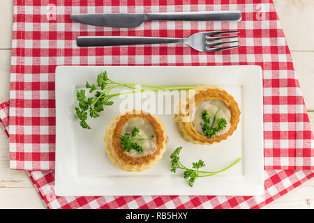 La pâte feuilletée le vol-au-vents rempli de ragoût de champignons sur une plaque blanche Banque D'Images