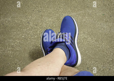 Homme poilu minces jambes en bleu sneakers Banque D'Images