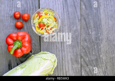 Salade de légumes avec des légumes frais couché séparément sur un fond gris vintage rustique en bois. Banque D'Images