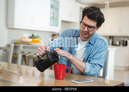 Man pouring coffee à partir de la presse française dans la tasse Banque D'Images