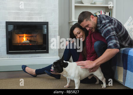 Couple avec leur chien de compagnie dans la salle de séjour Banque D'Images