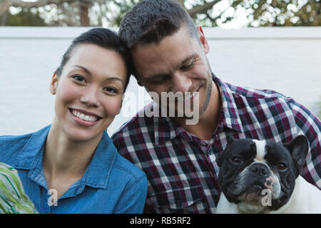 Couple avec leur chien dans le jardin Banque D'Images