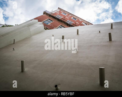 Mur de boue restauré avec des bâtonnets de bois surmontée d'ancien bâtiment rouge Banque D'Images