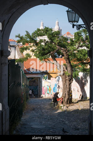 Lisbonne, Portugal - 27 mai 2018 : artiste de rue, sous un arbre, avec en arrière-plan l'église Saint-vincent photographié hors de tunnel Banque D'Images