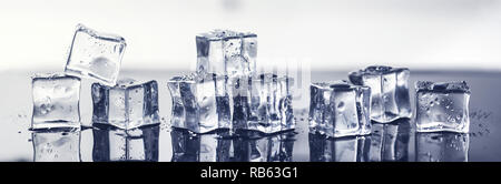 Cubes de glace humide sur la surface noire avec réflexion. banner Banque D'Images