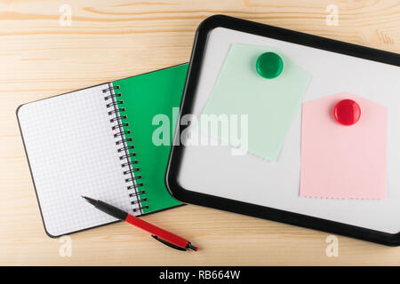 Tableau magnétique, carnet à spirales et stylo à bille sur fond de bois, vue du dessus Banque D'Images