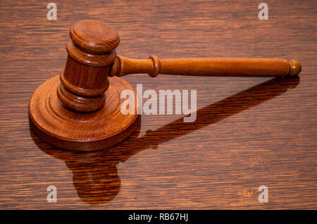 Un marteau de juge en bois repose sur une table texturée, prononçant la peine dans une salle d'audience. Banque D'Images