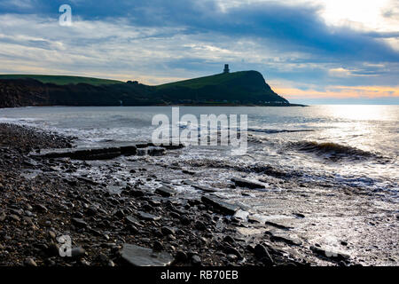 Photographie de paysage sur la plage de la baie de Kimmeridge du lave-ledge sur l'eau donnant sur la tour Clavell sous moody skies. Banque D'Images