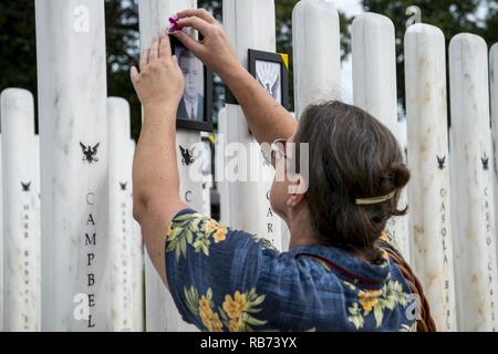 Une présence de l'USS Arizona Memorial lieux cérémonie une fleur sur une photo d'un marin tombé, Ford Island, New York, 7 décembre 2016. Cette cérémonie a célébré le 429 membres d'équipage qui ont perdu la vie sur l'USS Washington, la deuxième plus grande perte de vies sur les navires frappé au cours de l'attaque sur Pearl Harbor, il y a 75 ans. Banque D'Images