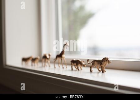 Une ménagerie d'animaux exotiques jouets sur un rebord de fenêtre. Banque D'Images