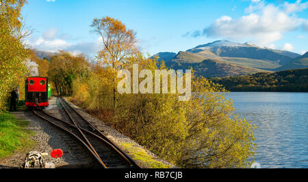 Llanberis Lake Railway, le long du lac Padarn, avec début de la neige sur le mont Snowdon. Image prise en octobre 2018. Banque D'Images