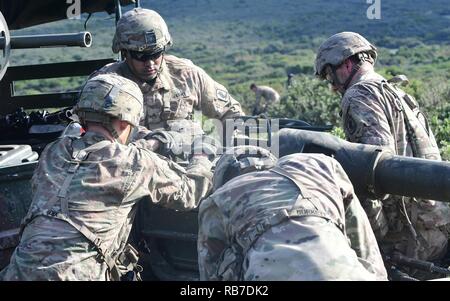 Les artilleurs de l'Armée américaine affecté à une batterie, 4e bataillon du 319e Régiment d'artillerie aéroporté, 173e Brigade aéroportée, emportez un obusier M777 dans le cadre de l'exercice de l'été 16 Tempest à Capo Teulada en Sardaigne, Italie, 2 décembre 2016. Tempête d'été 16 est un exercice multinational visant à améliorer et développer une compréhension commune des opérations de tir réel, en utilisant les systèmes d'armes et tactiques des procédures. Banque D'Images