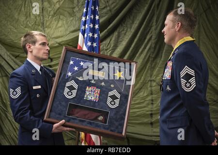 JOINT BASE ELMENDORF-RICHARDSON, Alaska -- une pararescueman avec le 212e Escadron de sauvetage, Alaska Air National Guard, présente une ombre fort au chef Master Sgt. Paul 'Bear' Barendregt, un pararescueman et chef de l'enrôle manager pour le QR 212, au cours de sa retraite cérémonie à la 212ème ici de l'immeuble du siège, le 3 décembre 2016. Depuis l'adhésion à l'Alaska Air National Guard en 1999, Barendregt a devenir des des plus accomplis et reconnaissable de visages de sauvetage en milieu sauvage de l'Alaska. Il est personnellement le mérite de sauver 106 vies sauvées aider 43 autres survivants au cours de Banque D'Images