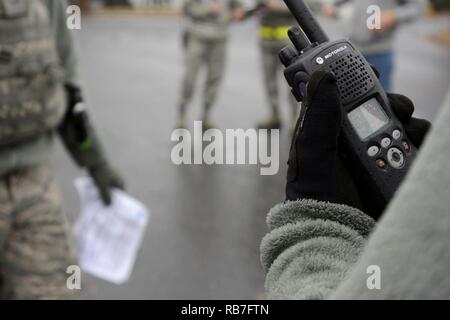 U.S. Air Force d'un membre de la 1re classe Dustin Shepard (droite), 145e Escadron des Forces de sécurité, les radios dans l'information concernant un suspect appréhendé et près de véhicule abandonné au cours d'un exercice qui a eu lieu au North Carolina Air National Guard (NCANG) de base, l'aéroport international de Charlotte Douglas, le 4 décembre 2016. Le but de l'exercice est de tester la capacité de l'NCANG d'effectuer des mesures de sécurité, répondre à un agent biologique, et fournir des soins médicaux d'urgence dans un scénario réel. Banque D'Images