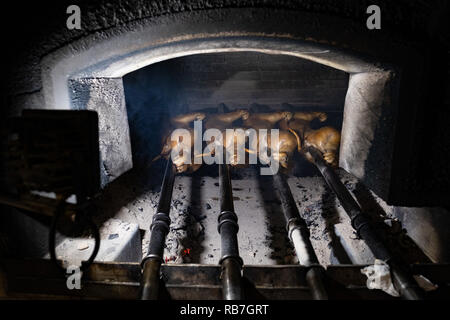 Crache sur les porcelets à l'intérieur d'un four de grillage dans la région de Bairrada traditionnels portugais, Mealhada, Portugal Banque D'Images