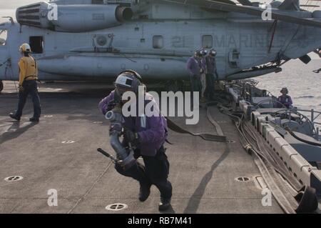 Mer Méditerranée (déc. 6, 2016) Seaman Aaron Woods porte un tuyau pour se ravitailler en avion sur le pont d'envol du navire d'assaut amphibie USS Wasp LHD (1) le 6 décembre 2016. Le Wasp est déployé avec le groupe amphibie Wasp pour appuyer les opérations de sécurité maritime et les efforts de coopération en matière de sécurité dans le théâtre américain dans la 6ème zone d'opérations de la flotte. Banque D'Images