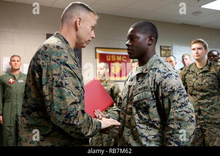 Le brig. Le général Matthew Glavy, gauche, félicite les nouveaux promus Lance Cpl. Trevor Stone avec un défi coin à bord de Marine Corps Air Station Cherry Point, N.C., 7 décembre 2016. Dans la tradition du Marine Corps, Marine Corps pièces défi sont donnés pour montrer l'appréciation pour un travail bien fait. Pierre a été meritoriously promu au grade de caporal suppléant pour son excellent travail pendant leur affectation à l'Escadrille de véhicules aériens télépilotés Marine, Marine 2 Groupe d'aéronefs 14, 2nd Marine Aircraft Wing. Glavy est le commandant général du 2ème MAW et Pierre est un électricien affecté à VMU-2. Banque D'Images